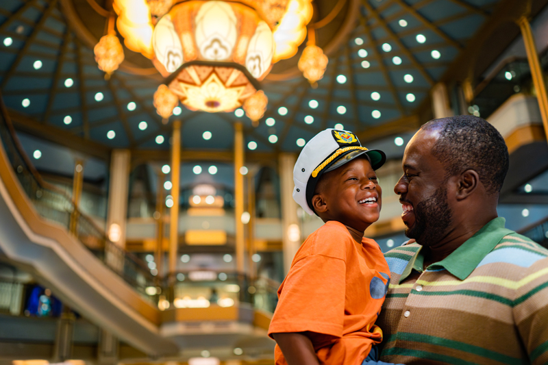Father and son smiling aboard Disney Treasure