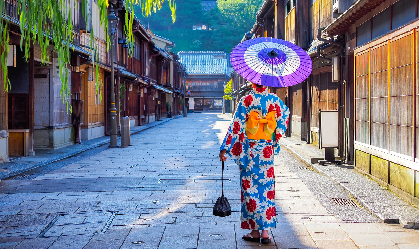 Woman strolling through a Japanese street with an umbrella