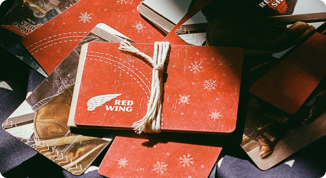 Red Wing gift cards appearing one at a time onto a wooden surface